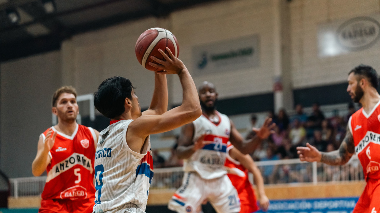 Players contesting a shot during an indoor basketball game