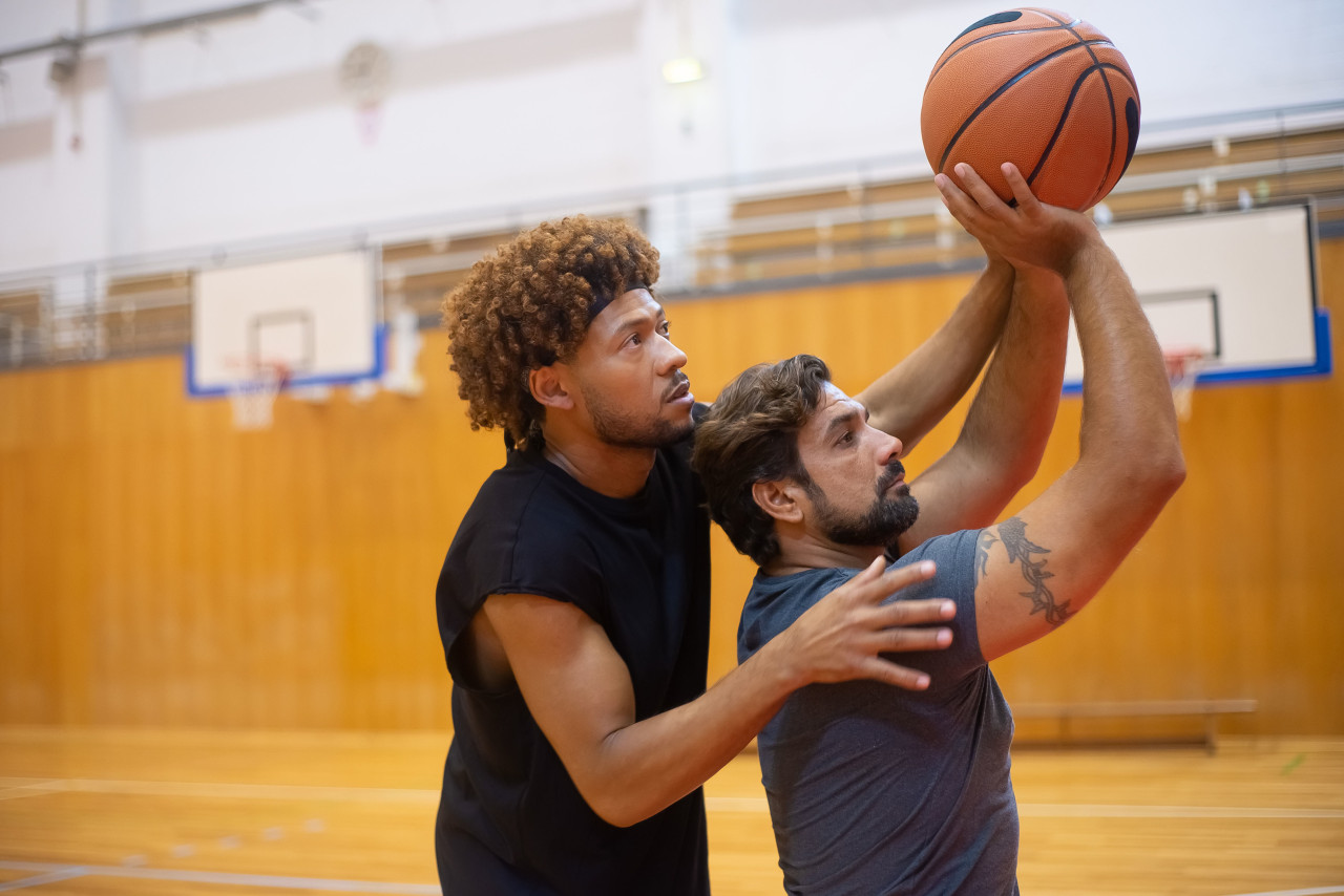 Two players working on shooting form during an indoor practice