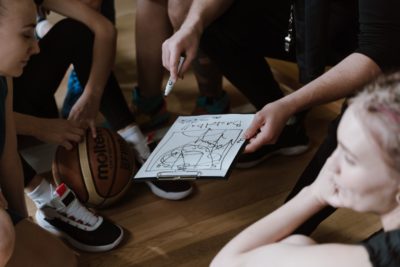 A coach showing a play diagram during a team huddle